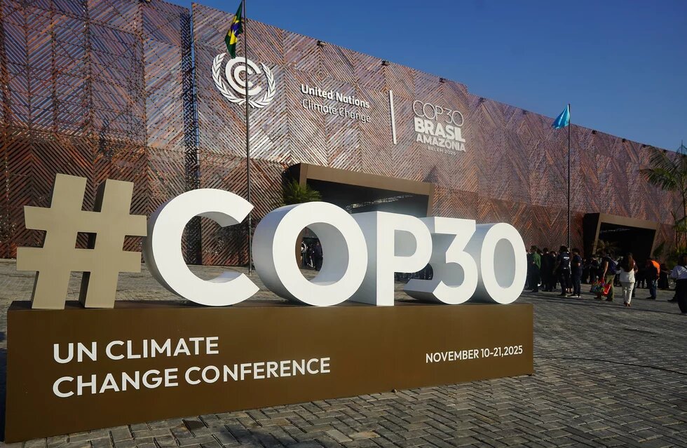 Ein Aufsteller des Logos der COP 30 steht vor einem Gebäude. 