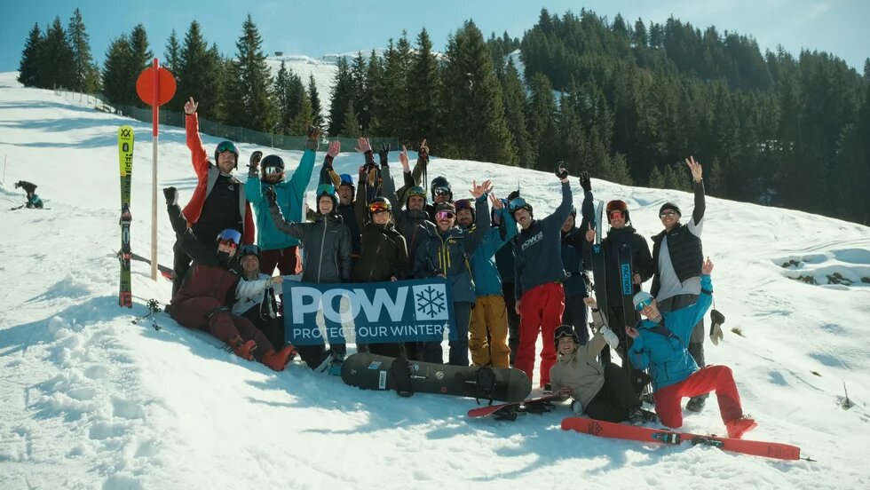 Eine Gruppe von Skifahrer*innen auf einem beschneiten Hügel.