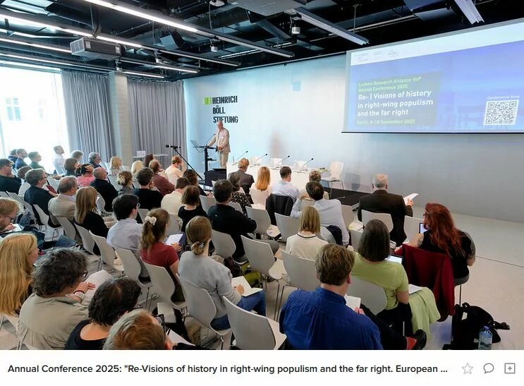 Person spricht am Rednerpult vor sitzendem Publikum; auf der Leinwand Konferenztitel zu Rechtspopulismus und Geschichte.
