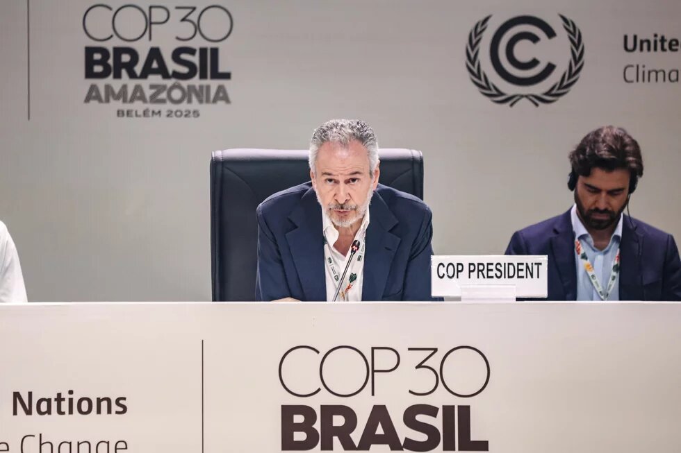 A man speaks as "COP President" at the COP30 climate conference in Belém, Brazil; another man with headset sits to his right.