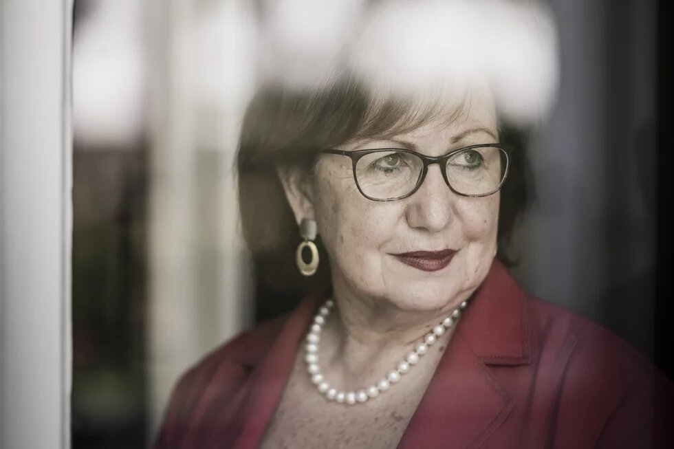 Portrait Prof. Dr. Seyla Benhabib - mit Brille blickt nach rechts aus einem Fenster, Spiegelungen verdecken Teile des Gesichts.