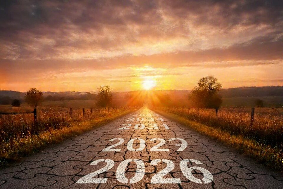 Gerade Straße aus Puzzleteilen mit Jahreszahlen 2026 bis 2033, führt in Sonnenaufgang zwischen Feldern und Bäumen.