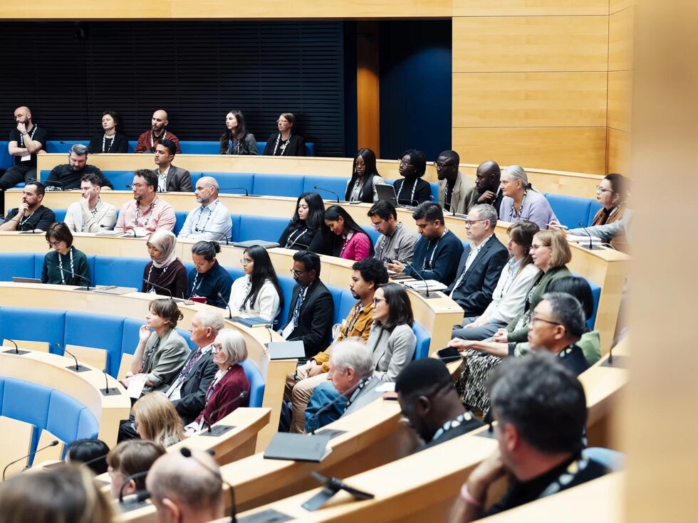 Das Foto zeigt eine mehrere Personen auf einer Zuschauertribüne.