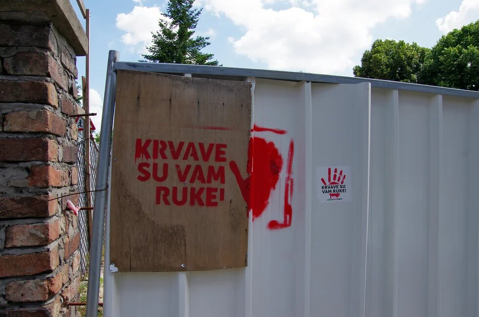 Das Foto zeigt den mit roter Farbe an eine Wand gesprühten Slogan »Krvave su vam ruke!« (Eure Hände sind blutverschmiert) in Serbien.
