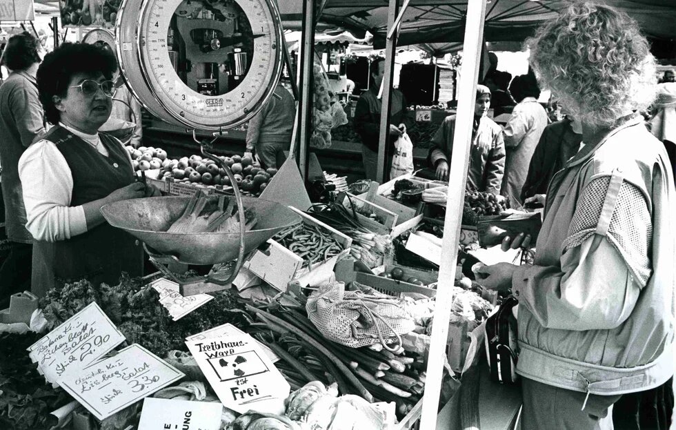 Stand auf einem Wochenmarkt in Köln. Ein Verkäufer weist darauf hin, dass sein Salat aus dem Treibhaus stamme und somit nicht radioaktiv verseucht sei, 07.05.1986.