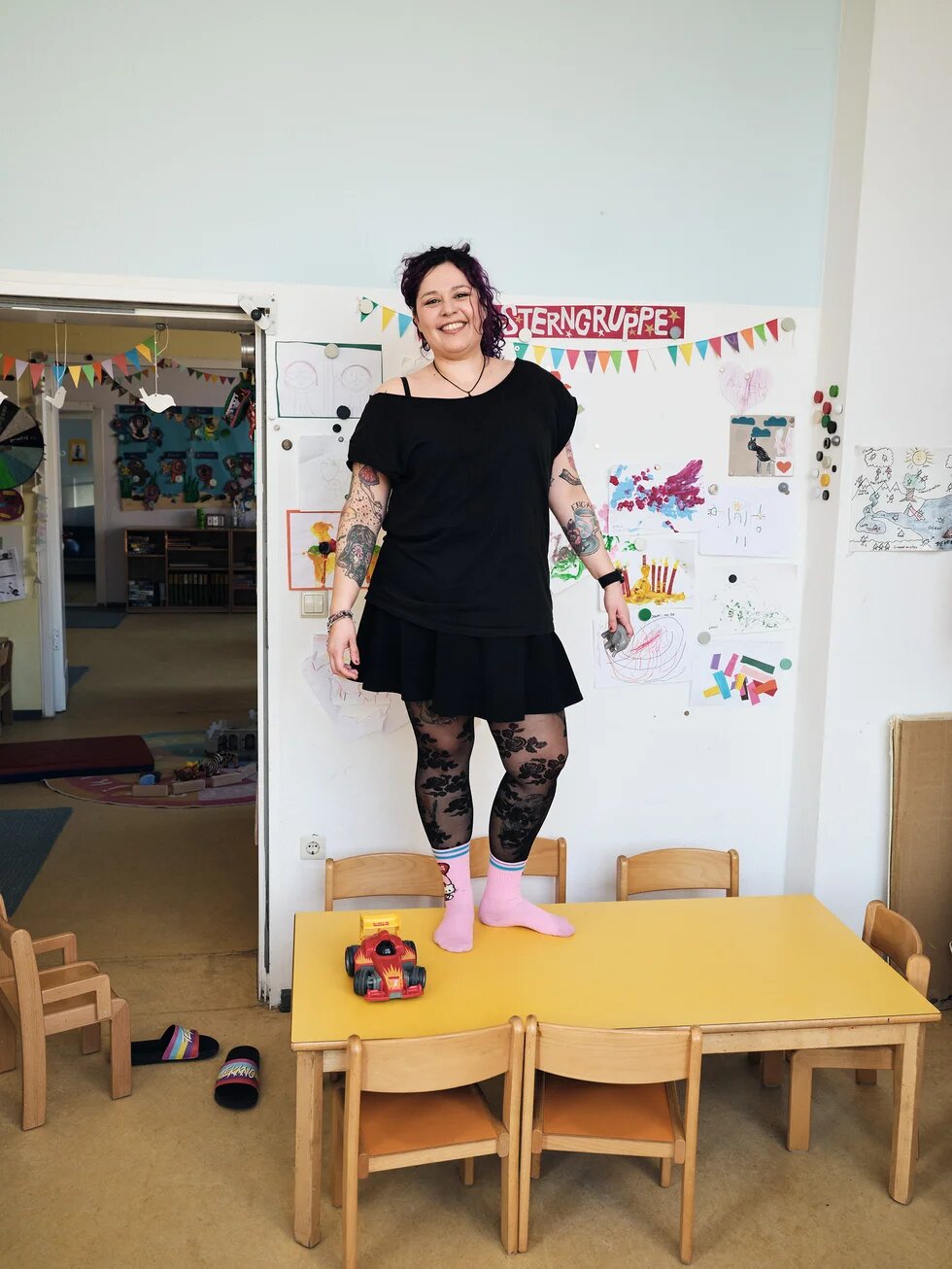 Mimi steht auf einem Tisch in der Kindertagesstätte, in der sie arbeitet.