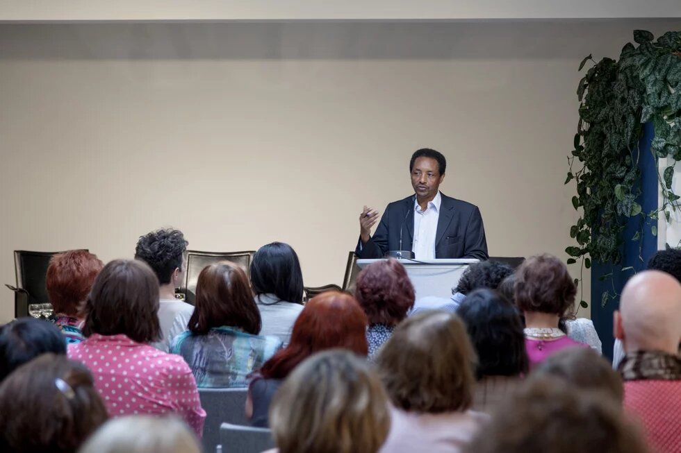 Mekonnen Mesghena von der Heinrich-Böll-Stiftung begrüßt die Gäste im Italienisches Kulturinstitut Berlin zur Veranstaltung "Andiamo! Europa in Bewegung"
