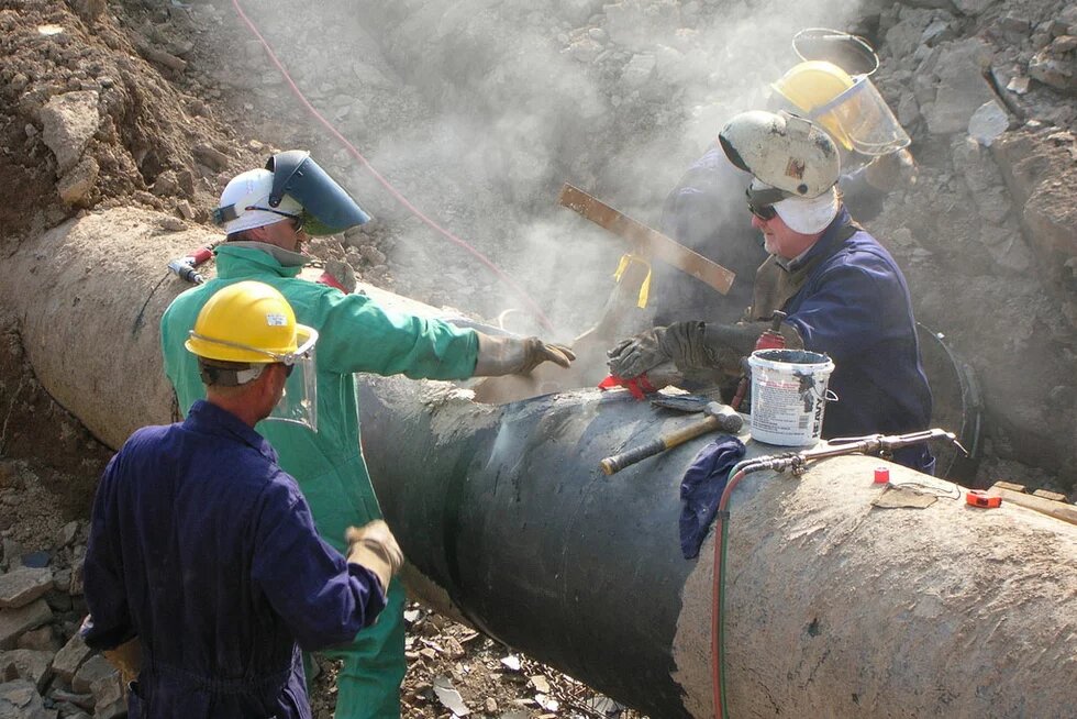 Bauarbeiter arbeiten an einer Pipeline Bauarbeiter arbeiten an einer Pipeline