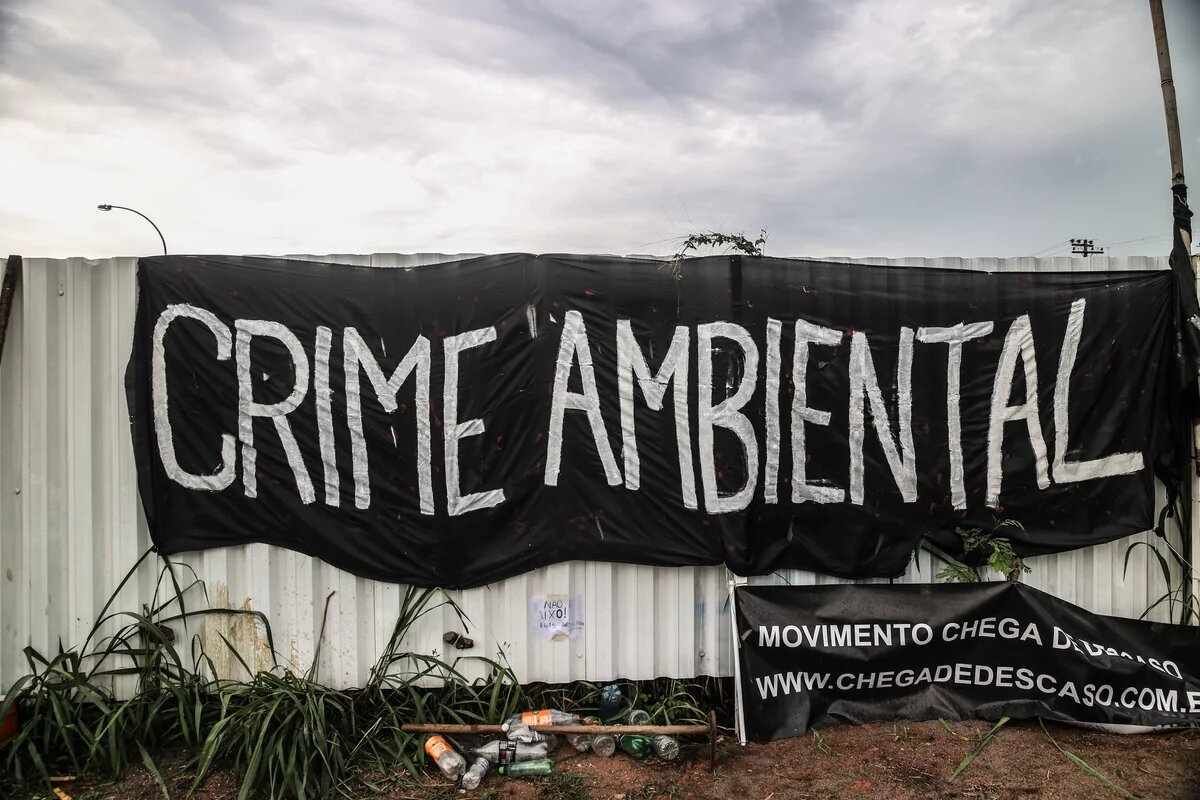 Protestplakat mit dem Titel „Umweltverbrechen“ vor dem eigens für die Olympischen Spiele angelegten Golfplatz in Rio de Janeiro. Protestplakat „Umweltverbrechen“