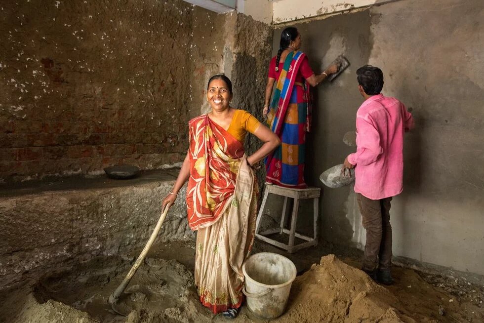 Hausrenovierung in Ahmedabad, Indien Bhanu Ben Jadav mischt Zement in einem Haus, das renoviert wird.