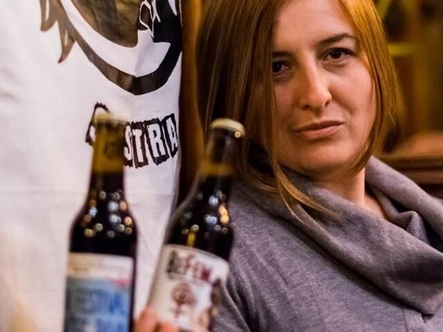 Leila Šeper Leila Šeper vor dem Logo ihrer Brauerei mit zwei Bierflaschen