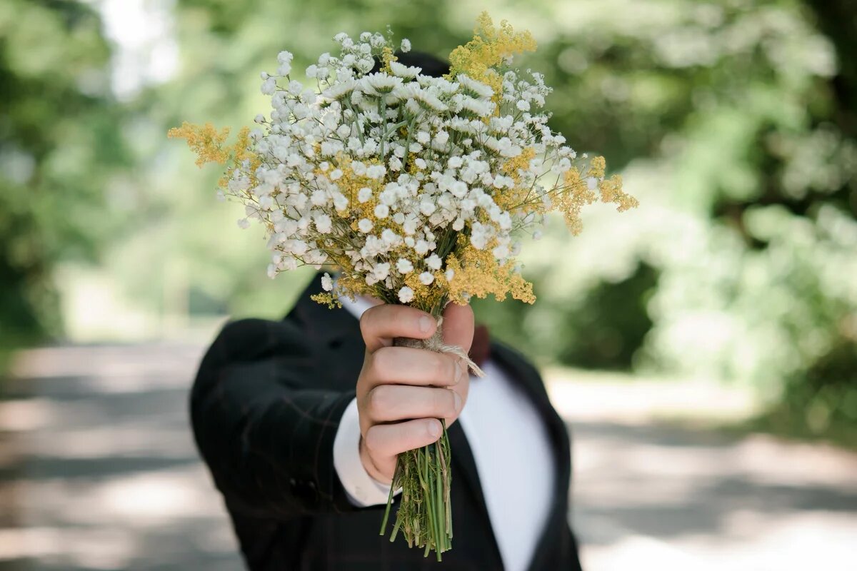 Blumen für Beate Klarsfeld Ein Mann hält einen Blumenstrauß