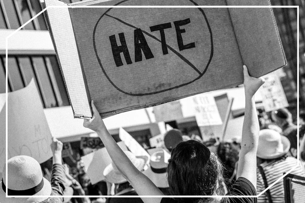 Um Vertrauen aufzubauen, muss Hate Speech in den europäischen Medien gestoppt werden Eine Frau hält ein Plakat auf einer Demo, auf dem "Hate" steht und durchgestrichen ist