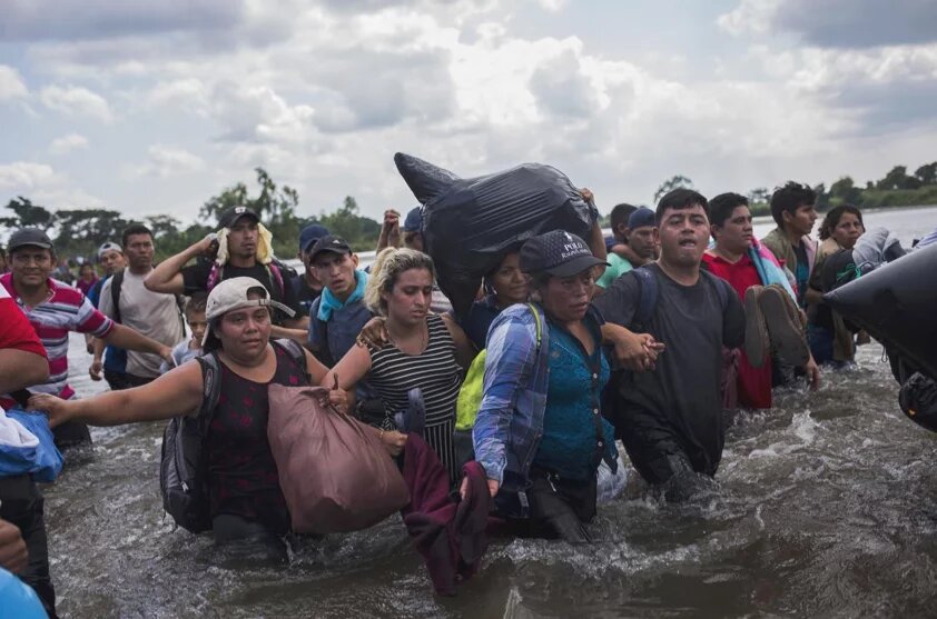Die Migration und das Schweigen Menschen überqueren zu Fuß einen Fluss