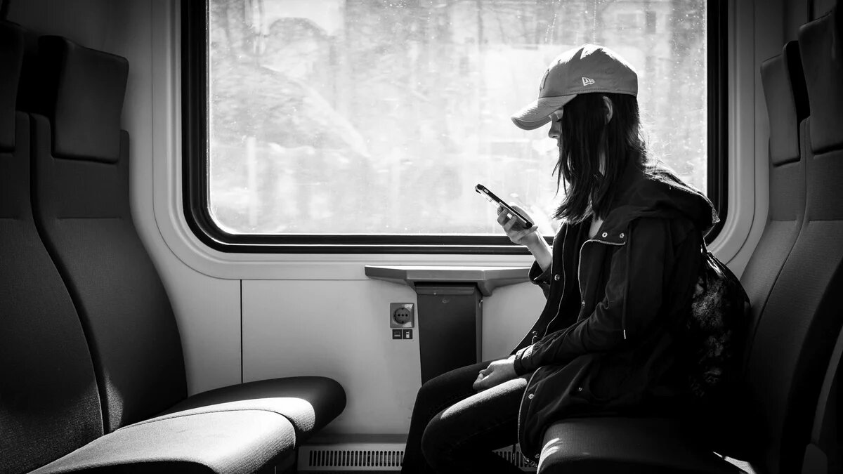 Kommunale Verkehrswende: Smart City Helsinki bietet eine Flatrate für alle Verkehrsmittel Kommunale Verkehrswende. Smart City Helsinki. Foto einer Frau im Zug mit Smartphone