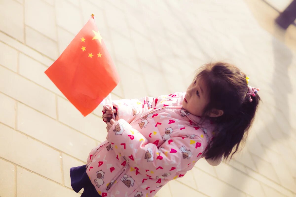 „Die große Wiederbelebung“: Chinas junge Nationalist/innen „Die große Wiederbelebung“: Chinas junge Nationalist/innen - Ein chinesisches Mädchen hält eine chinesische Flagge.