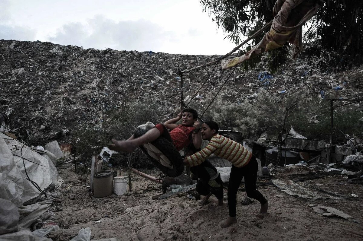 Abfallwirtschaft in Gaza: Gefahren und Herausforderungen Bild: Spielende Kinder nahe ihres Wohnorts in Khan Younis (Gaza). Im Hintergrund ist eine wilde Müllkippe zu sehen.