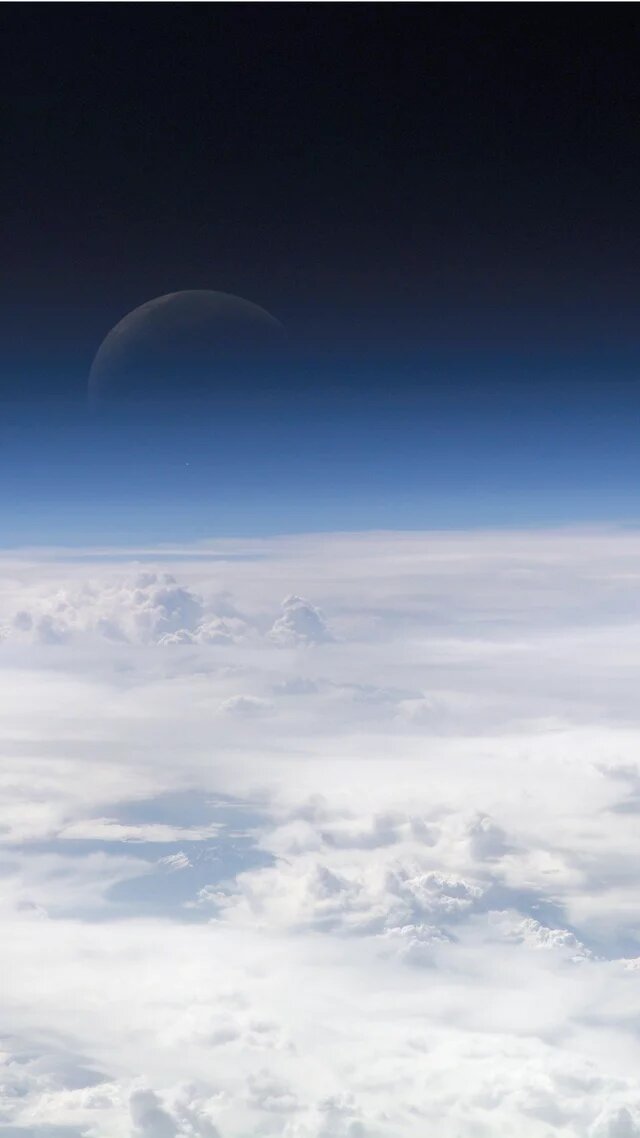 Foto: Atmosphäre der Erde, aufgenommen von der ISS (2013). Im Hintergrund ist der Mond teilweise sichtbar.