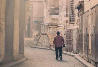 Man walks down a narrow empty street in Cairo, Egypt.