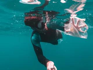 Man catching plastic under water