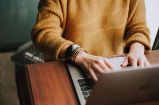 Person, die am Laptop schreibt