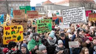 Junge Menschen demonstrieren mit Schilden und Plakaten für mehr Klimaschutz