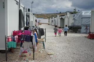Syrisches Flüchtlingslager in den Außenbezirken von Athen. Flüchtlingskinder spazieren durch ein Flüchtlingslager.