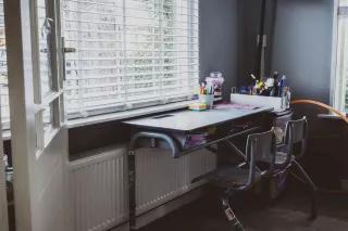 Kein Zugang, kein Unterricht Ein fast leerer Kinderschreibtisch ohne digitale Geräte vor einem Fenster
