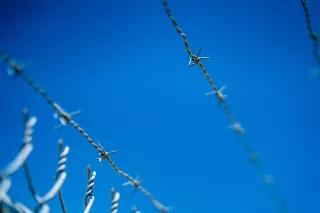 Stacheldrahtzaun Stacheldrahtzaun vor blauem Himmel