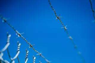 Stacheldrahtzaun vor blauem Himmel