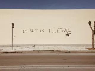 Schutzsuchende kommen nach Griechenland Eine Wand ist mit dem Satz "No one is illegal" beschriftet