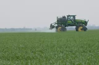 Ein Traktor düngt ein Feld Ein Traktor düngt ein Feld