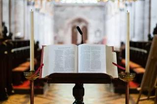 Blick von der Kanzel Religionspolitik heute - Ausblick von einer Kanzel auf eine aufgeschlagene Bibel und den leeren Kirchinnenraum.