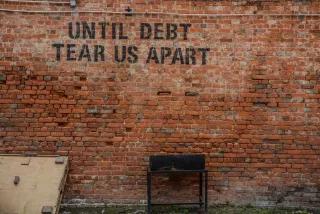 "Until Debt Tear us Apart" Eine Backsteinwand auf der in schwarzen Buchstaben steht: "Until Debt Tear us Apart"