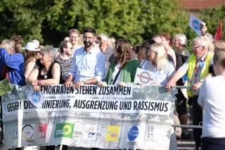 Gegendemonstration gegen eine AFD-Wahlveranstaltung in Hessen, September Mehrere Menschen halten bei einer Kundgebung einen großen Banner in den Händen, auf dem "Demokraten stehen zusammen gegen Diskriminierung, Ausgrenzung und Rassismus" steht; darunter sind die Logos folgender Parteien platziert: CDU, SPD, FW, FDP, Offene Liste.