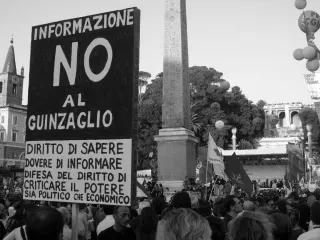 A Demonstration for freedom of press in Rome, Italy. In the foreground a sign saying "Right to Knowledge, Duty to Inform, Defense of the Right to Criticize Both Political and Economic Power"