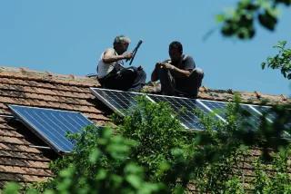 Zwei Männer montieren Solarkollektoren auf einem Dach