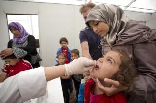 Fatima, a Syrian refugee as her child vaccinated
