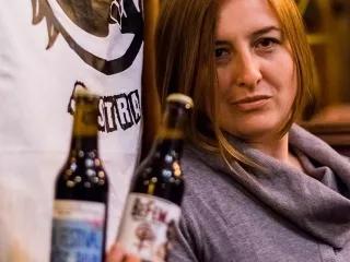 Leila Šeper Leila Šeper vor dem Logo ihrer Brauerei mit zwei Bierflaschen