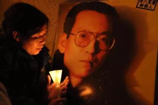 Demonstration von Amnesty International für die Freiheit von Liu Xiaobo (Januar 2010) Eine Frau mit einer Kerze vor einem Bild von Liu Xiaobo