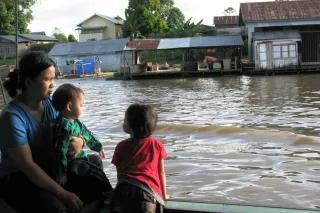 Der Mahakam in Kalimantan Timur, Indonesien Eine Mutter mit zwei Kindern auf einem Boot.
