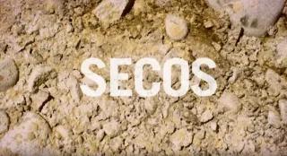 Schriftzug "Secos" auf trockenem, steinig braunem Untergrund