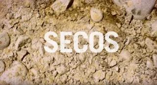 Titelbild Dokumentarfilm Schriftzug "Secos" auf trockenem, steinig braunem Untergrund
