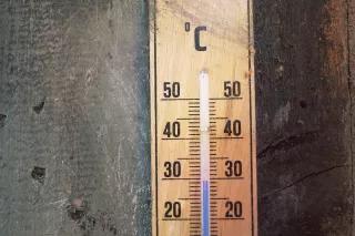 Ein altes Thermometer an Holzwand