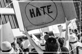 Um Vertrauen aufzubauen, muss Hate Speech in den europäischen Medien gestoppt werden Eine Frau hält ein Plakat auf einer Demo, auf dem "Hate" steht und durchgestrichen ist