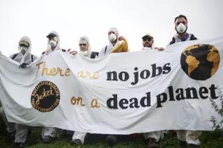 Lehren aus der Kohlekommission Lehren aus der Kohlekommission: Eine Gruppe in weiß gekleideter Protestant/innen hält ein Banner mit der Aufschrift "there are no jobs on a dead planet".