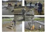 Mitglieder der RoF fluten das Reisfeld mit Flusswasser und schieben das Oberflächenwasser, das radioaktives Cäsium enthält, mit Bürstengeräten in einen Abflussgraben. 