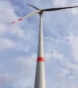 Windrad ragt in einen blauen Himmel mit weißen Wolken
