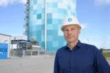 Roland Schulz mit Helm, im Hintergrund der riesige Wärmespeicher