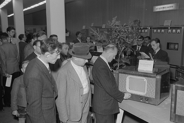 Besucher betrachten den Fernsehempfänger FE 852 B am Stand des VEB Sachsenwerk Radeberg, Technische Messe 1953